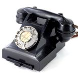 A black Bakelite vintage telephone, with chrome dial with label for Peterborough, number to