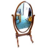 A late 19thC Sheraton revival mahogany cheval mirror, with circular beveled plate on U shaped