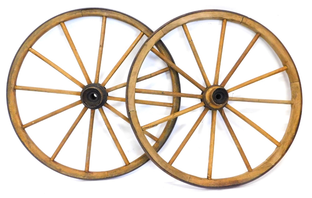 A pair of early 20thC spoked cartwheels, with metal outlines and centres, 105cm diameter.