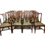 *A set of sixteen mahogany dining chairs in George III style, each with a pierced splat and a green