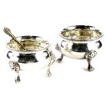 A pair of silver plated salts, each of circular form, with rope twist border and paw feet headed