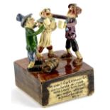 A Will Young Devon Studio pottery musical figure group, bearing a slogan for 'us wants to go to