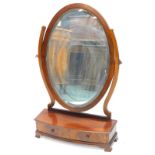 A mahogany dressing table mirror, the oval plate with a bevel edge on shaped supports with a bow