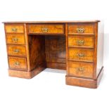 A Victorian walnut kneehole desk, the top with a green leather inset and a moulded edge, above an