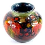 A Moorcroft pottery globular vase, decorated with fruits and berries in autumn shades, blue, etc.,