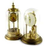 Two brass anniversary clocks, one example stamped Kern on spirally turned supports and a domed