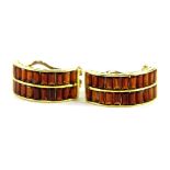A pair of 18ct gold garnet set half hoop earrings, each set with two rows of baguette cut garnets,