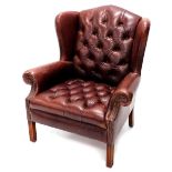 A Wade brown leather wingback armchair, with a button back and seat, on chanelled legs.