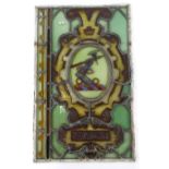 A 19thC stained glass panel, decorated with a crest of an armoured arm with bent elbow and an axe,