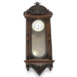 A late 19th/early 20thC continental walnut wall clock, with the elaborate composition crest,