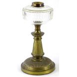 A Victorian reeded brass oil lamp base, with clear faceted glass reservoir, 35cm high.