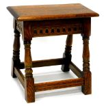 An oak joint stool, the rectangular top with a moulded edge, above a frieze decorated with flutes,