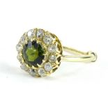 A peridot and diamond eternity ring, set with central round brilliant cut stone in claw setting,