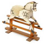A small dapple grey childs rocking horse, on trestle type base with metal brackets, 91cm wide.