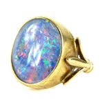 A 9ct gold opal dress ring, with opal doublet, in a rub over gold setting, with three splayed
