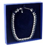 A two row Swarovski crystal necklace, set with row of blue and white crystals, in a white coloured