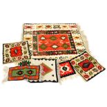 A modern Kilim rug, with a geometric design on a red ground with cream and brown borders, and