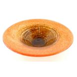 A Monart type glass dish, of circular form in speckled orange and brown colour way, unmarked, 35cm
