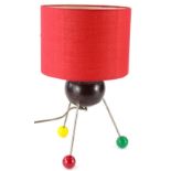 An unusual up-cycled table lamp, with a red shade, the body constructed from a bowling bowl and with