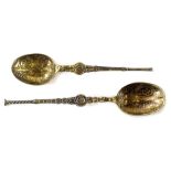 A pair of Eastern spoons, each with turned handles and elaborate bowls, unmarked, 11cm wide, etc. (