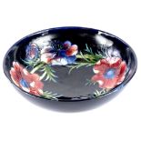 A Moorcroft pottery bowl, decorated with poppies on a navy blue ground, impressed and handwritten
