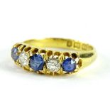 An 18ct gold sapphire and diamond gypsy ring, set with three cornflour blue sapphires and two