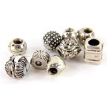 Nine Pandora charms, comprising a ladybird charm, a money bag, owl, rose, suitcase, heart, and three