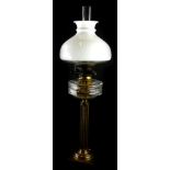 A Victorian brass effect oil lamp, with a facetted glass reservoir, 47cm high and an opaque shade