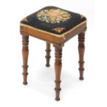 A 19thC mahogany stool, with a padded floral embroidered seat, on turned tapering legs, 29cm wide.