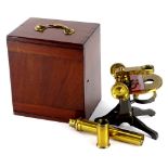 A brass students folding microscope, with various attachments in a mahogany case, the case 20cm