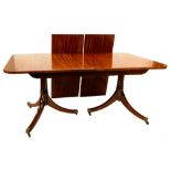 A mahogany two pillar dining table in Regency style, the rectangular top with a rounded cornice