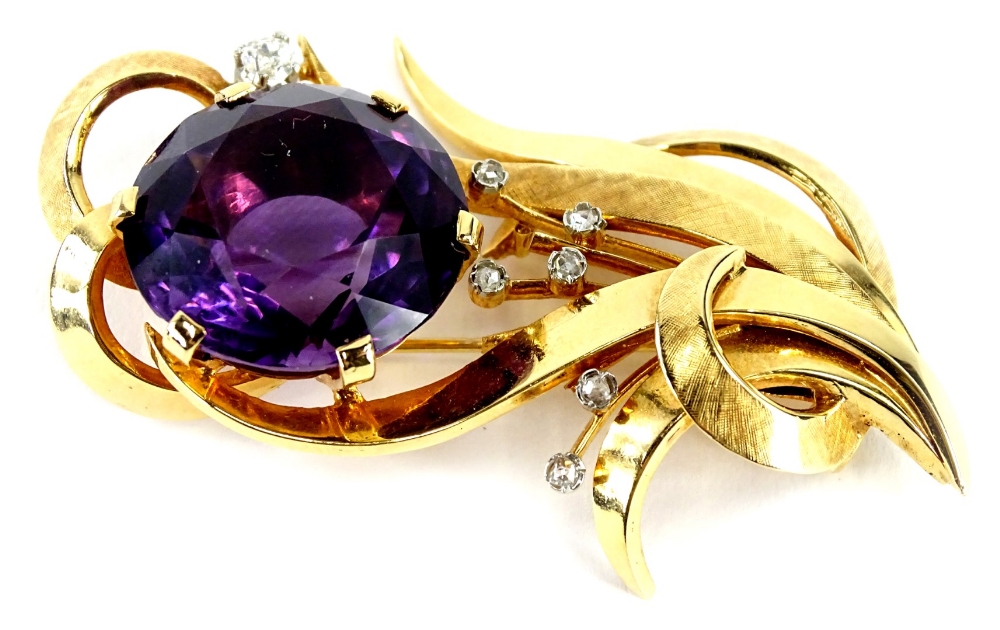 An amethyst and diamond spray brooch, set with single large amethyst 25mm x 15mm, in six claw