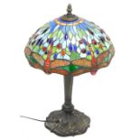 A Tiffany style table lamp, the stained glass shade decorated with dragonflies, the gilt bronzed