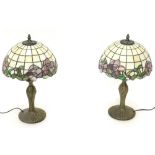 A pair of Tiffany style table lamps, each with a stained glass shade, decorated with purple flowers,