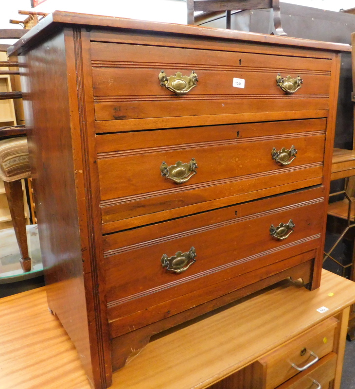 An Edwardian oak chest of three long drawers, with plate back handles.