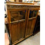 A mid-20thC oak cabinet with two panel doors, on block feet, 125cm high.
