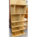 A light wood post modern open bookcase, of rectangular form, with various shelves, 182cm high.