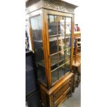 A mid-20thC oak freestanding cabinet, with a blind fret fixed cornice, raised above a panel door,