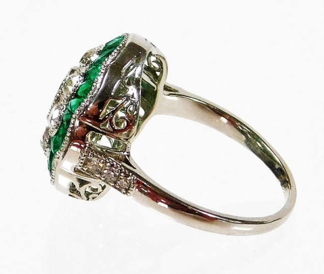 An emerald and diamond daisy style ring, the centre with oval cut emerald, surrounded by old cut dia - Image 2 of 2