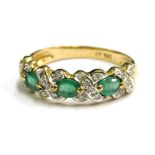 A modern emerald and diamond set 9ct gold dress ring, the design of three opal emeralds cross set wi