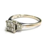 An 18ct white gold diamond set dress ring, with arrangement of four princess cut diamonds on raised