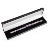 An 18ct white gold pink sapphire and diamond cluster line bracelet, the design with graduated oval c