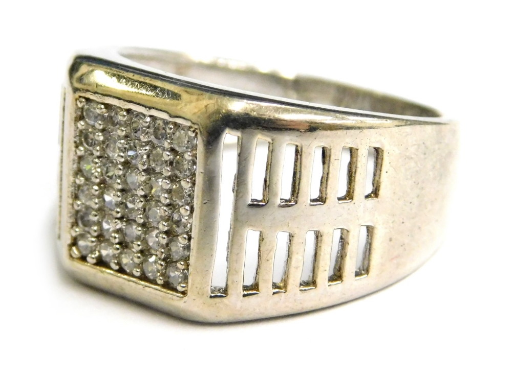 A silver dress ring, with pave set central white stone design and pierced design shoulders, ring siz