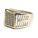 A silver dress ring, with pave set central white stone design and pierced design shoulders, ring siz
