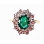 An 18ct gold emerald and diamond cluster ring, with oval cut emerald 8.6mm x 6.6mm x 3.8mm, totallin