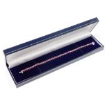 A ruby and diamond line bracelet, set with thirty oval cut rubies, each 3.8mm x 3mm x 1.2mm, totalli