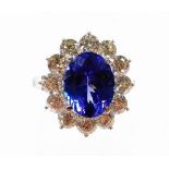 A tanzanite and diamond cluster ring, with oval cut AAA tanzanite, 4.95cts, in four claw setting, su