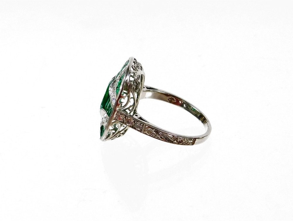 An Art Deco style emerald and diamond ring, with central oval cut emerald and further baguette cut e - Image 2 of 2