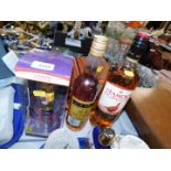 A 1 litre bottle of Famous Grouse whisky, together with a 70cl bottle of Couronnier Brandy and a