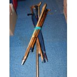 Assorted wooden walking sticks and an umbrella. (a quantity)
